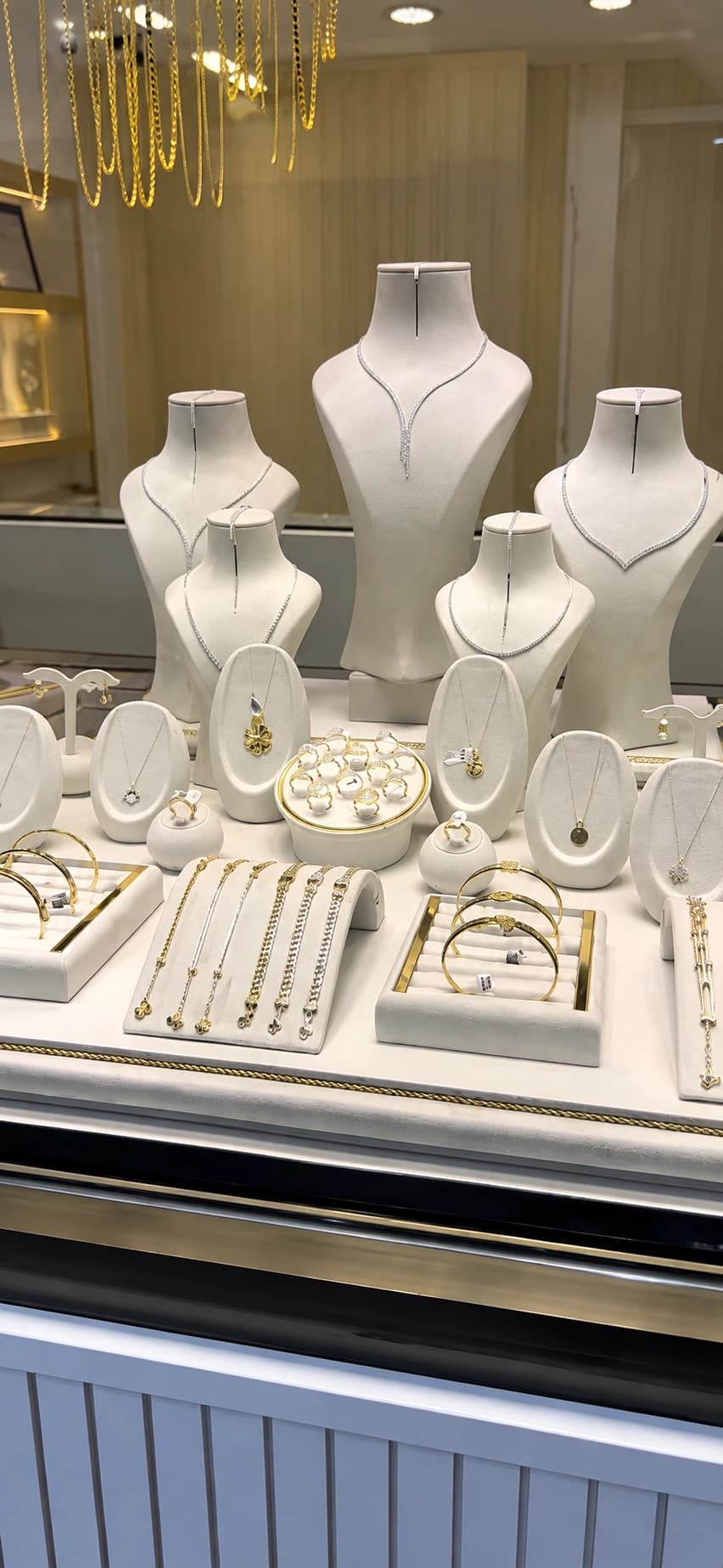 Kuyumcu vitrini dikey teşhir görünümü, beyaz mankenler ve altın takılar